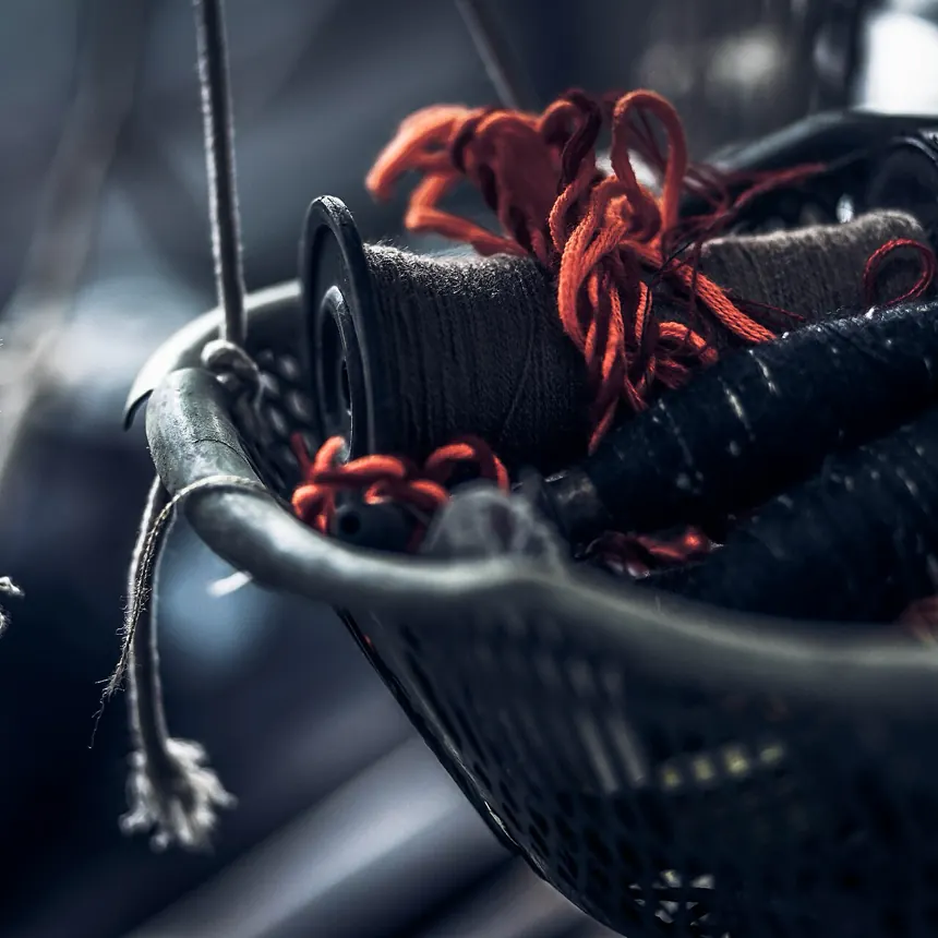 A basket of coral thread at the workroom bench where every sample is cut and sewn